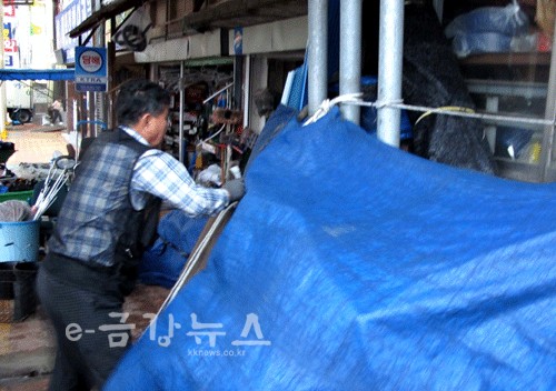 태풍으로 인해 강풍이 불자 시장 상인들이 문을 닫고 있다.