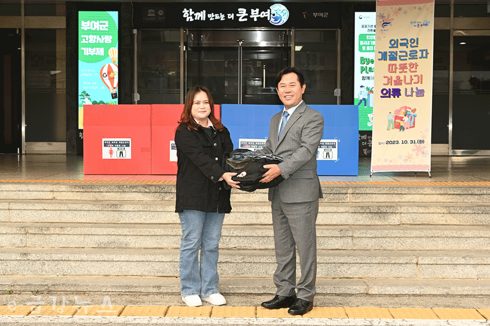 박정현 부여군수가 기부된 옷을 외국인 계절근로자에게 전달하고 있다.