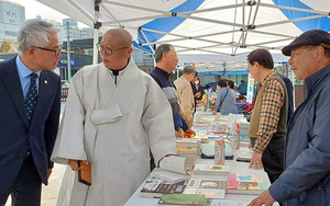 마곡사 원경 스님(중앙)이 전시된 책들을 살펴보며 이상표 시의원(좌)과 환담하는 장면